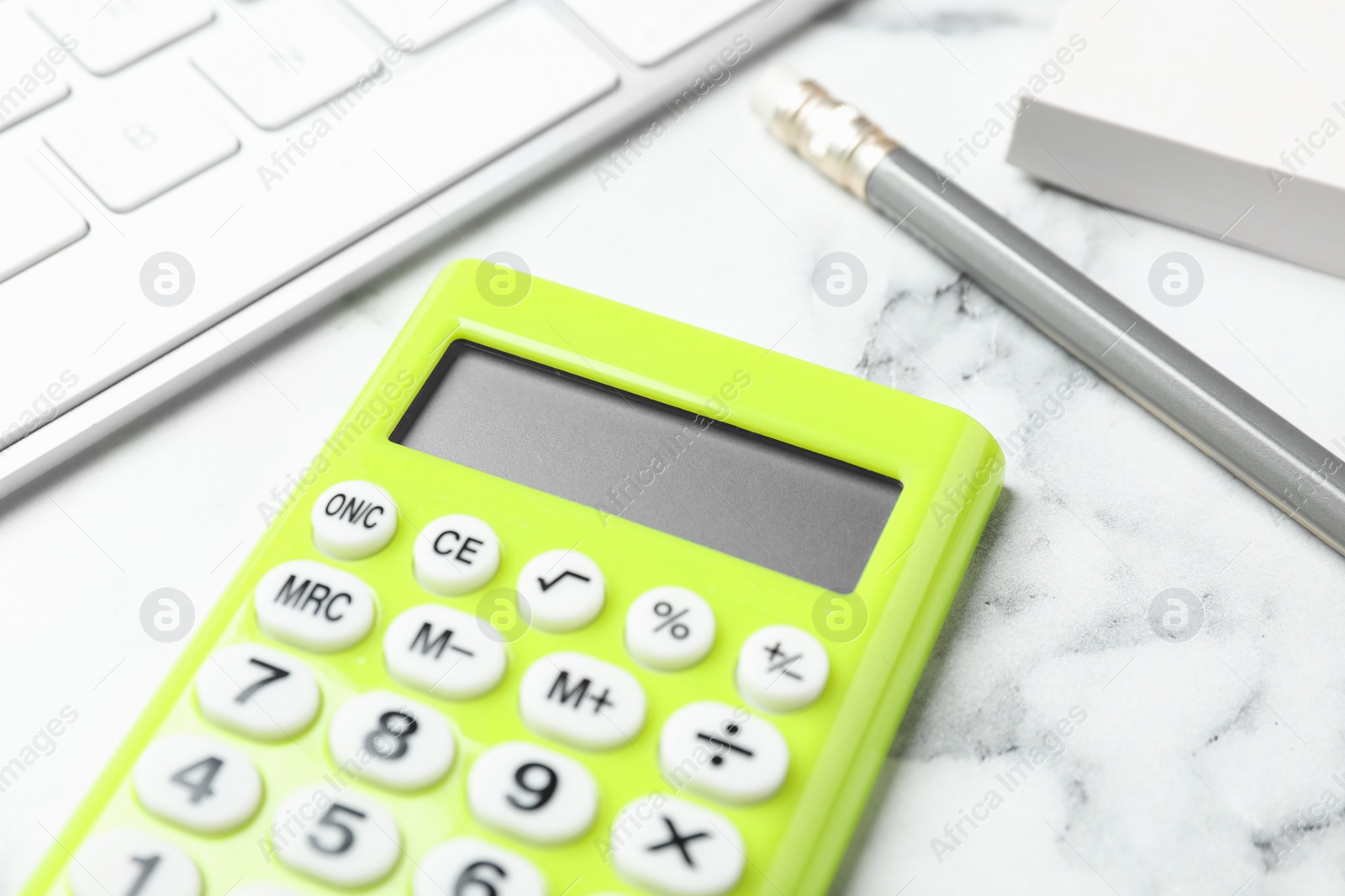 Photo of Calculator, keyboard and stationery on white marble table, closeup. Tax accounting