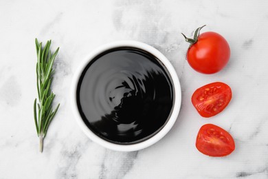 Photo of Organic balsamic vinegar, tomatoes and rosemary on white table, flat lay