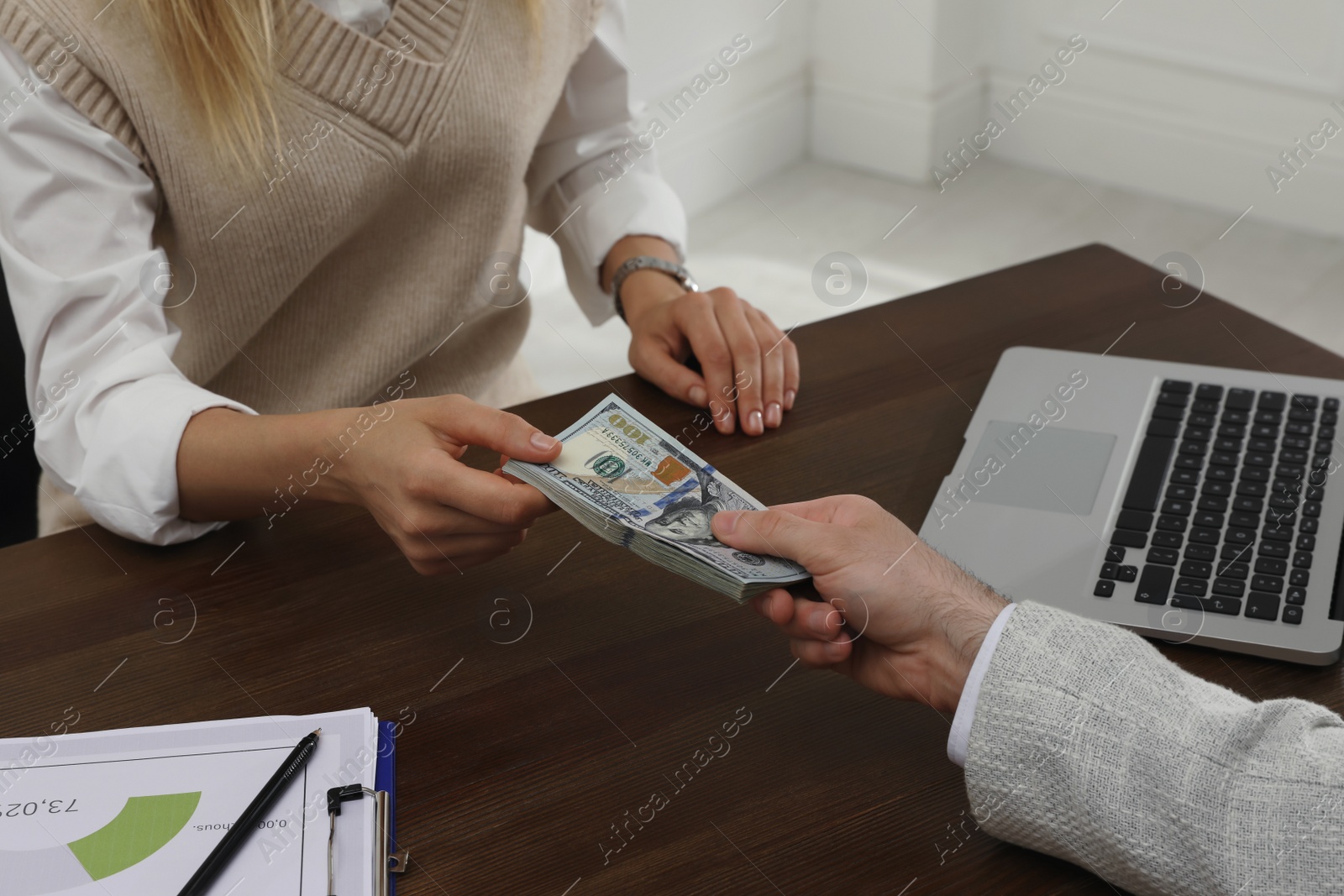 Photo of Cashier giving money to businessman at desk in bank, closeup