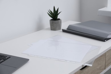 Photo of Punched pockets on white table in office