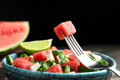 Photo of Delicious salad with watermelon served on black table, closeup