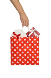 Photo of Woman holding paper shopping bag full of gift boxes on white background, closeup