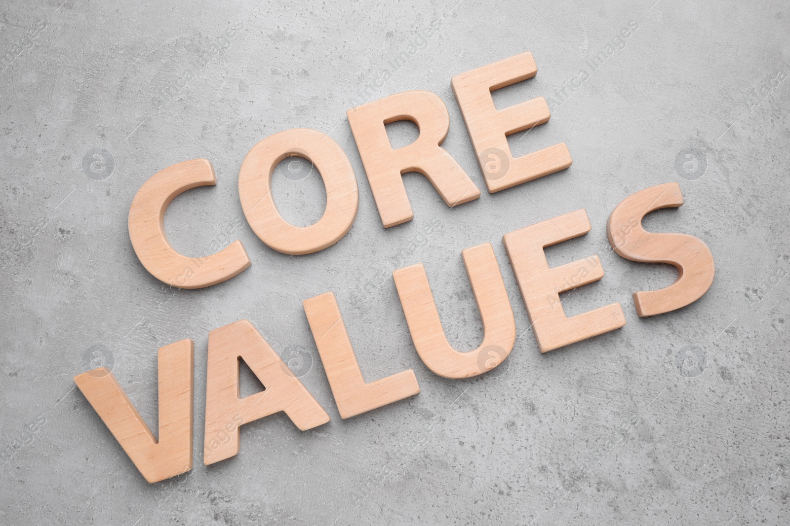 Photo of Phrase CORE VALUES made with wooden letters on grey background, flat lay