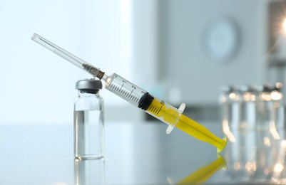 Syringe with vial of medicine on table