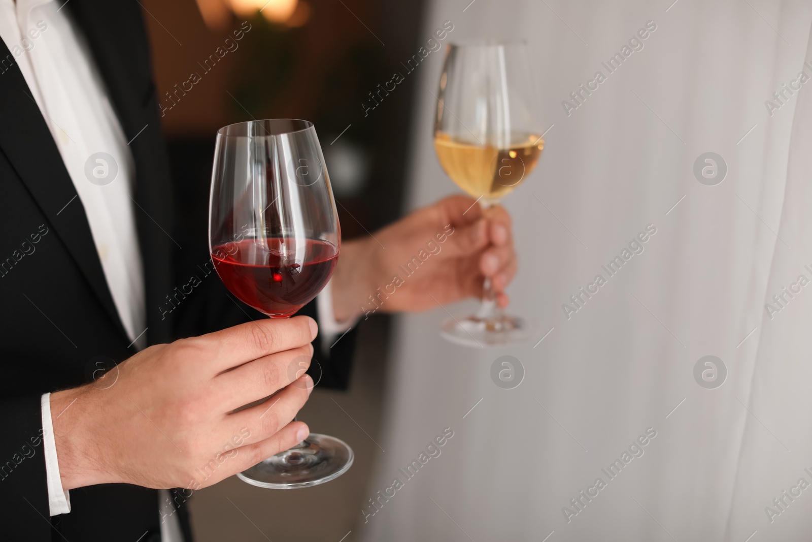 Photo of Young man with glasses of wine indoors