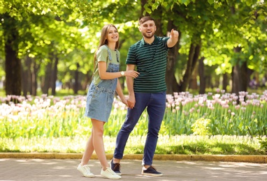 Happy young couple in green park on sunny spring day