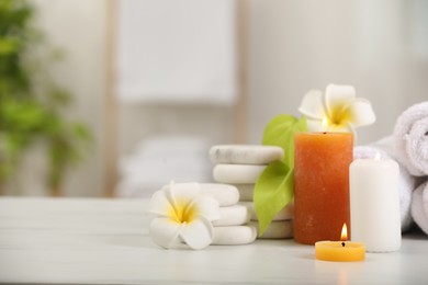 Composition with different spa products and plumeria flowers on white table indoors, space for text