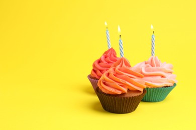 Photo of Delicious birthday cupcakes with bright cream on yellow background. Space for text