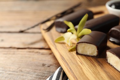 Photo of Glazed vanilla curd cheese bars on wooden table, closeup. Space for text