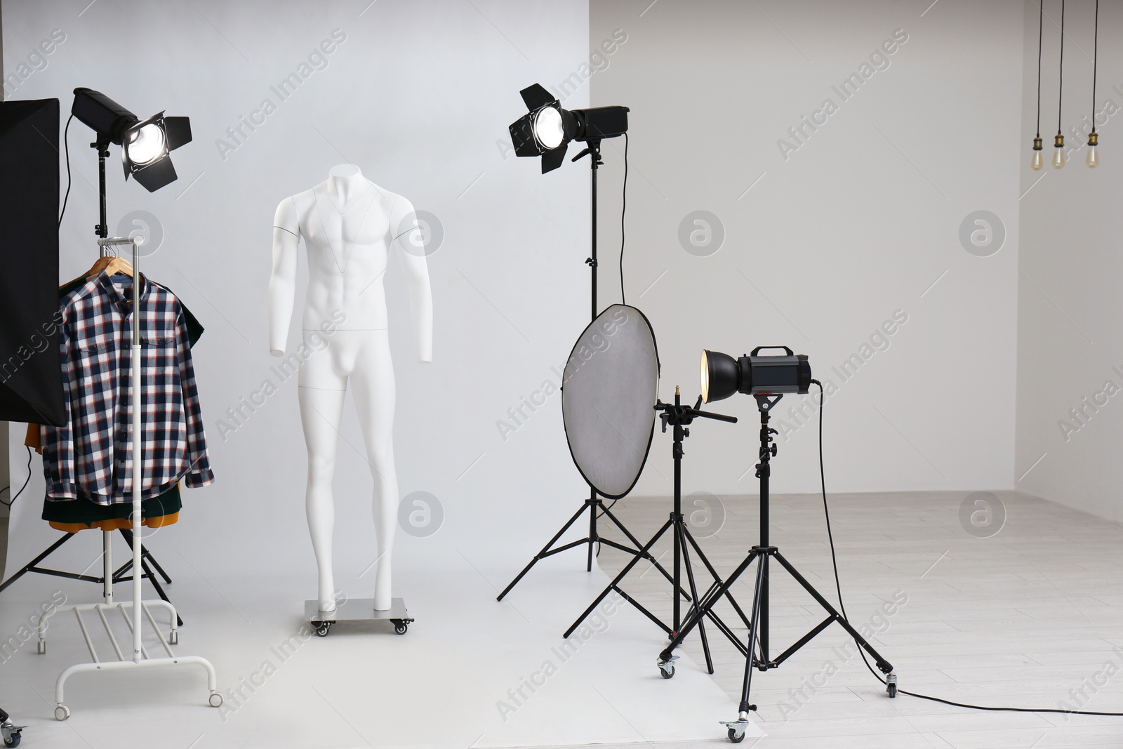 Photo of Ghost mannequin and rack with clothes in professional photo studio