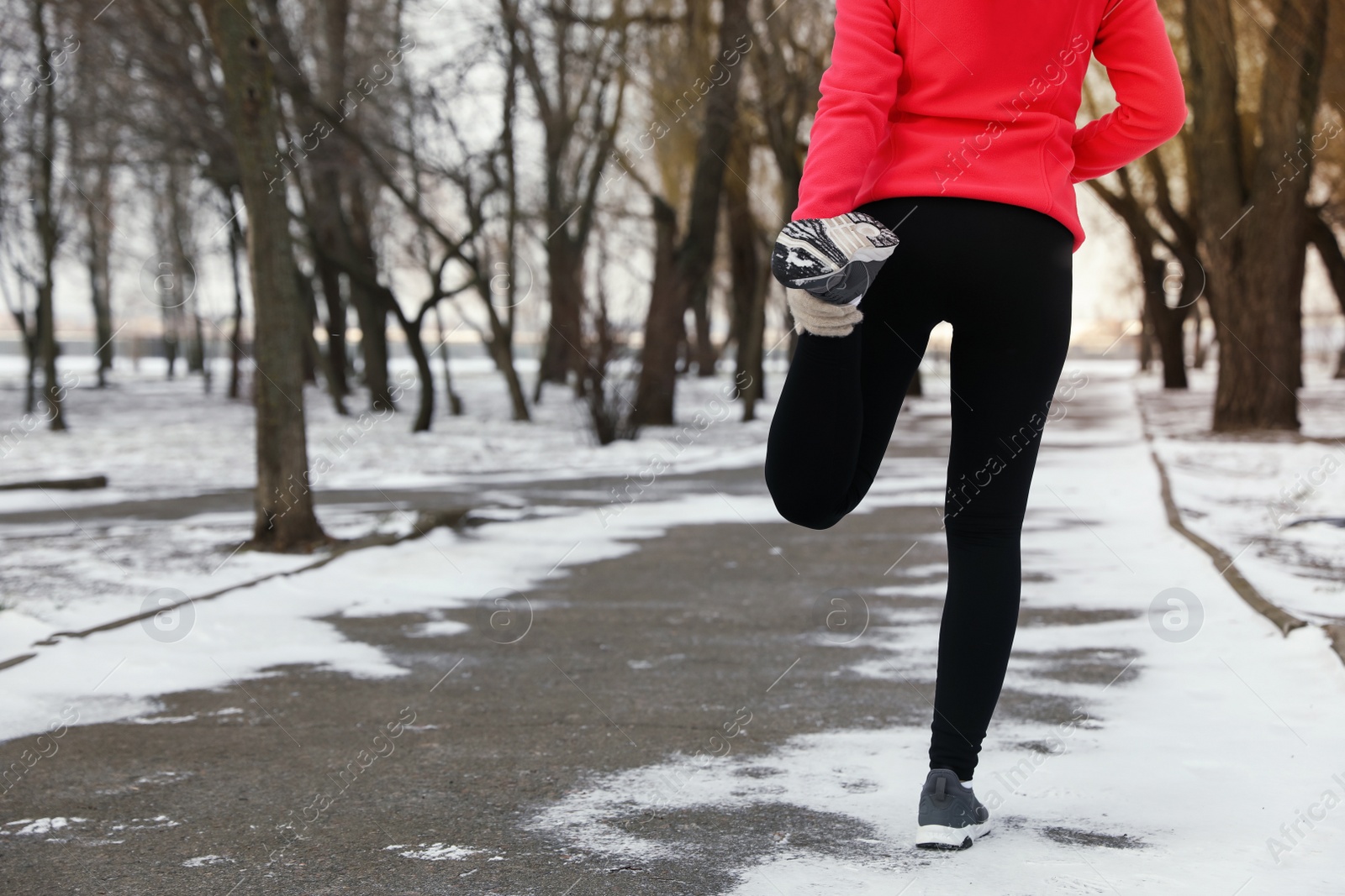 Photo of Woman doing sports exercises in winter park, closeup