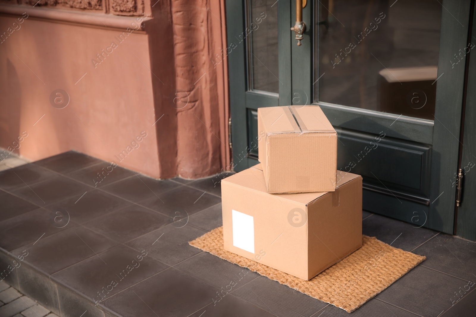 Photo of Delivered parcels on door mat near entrance. Space for text