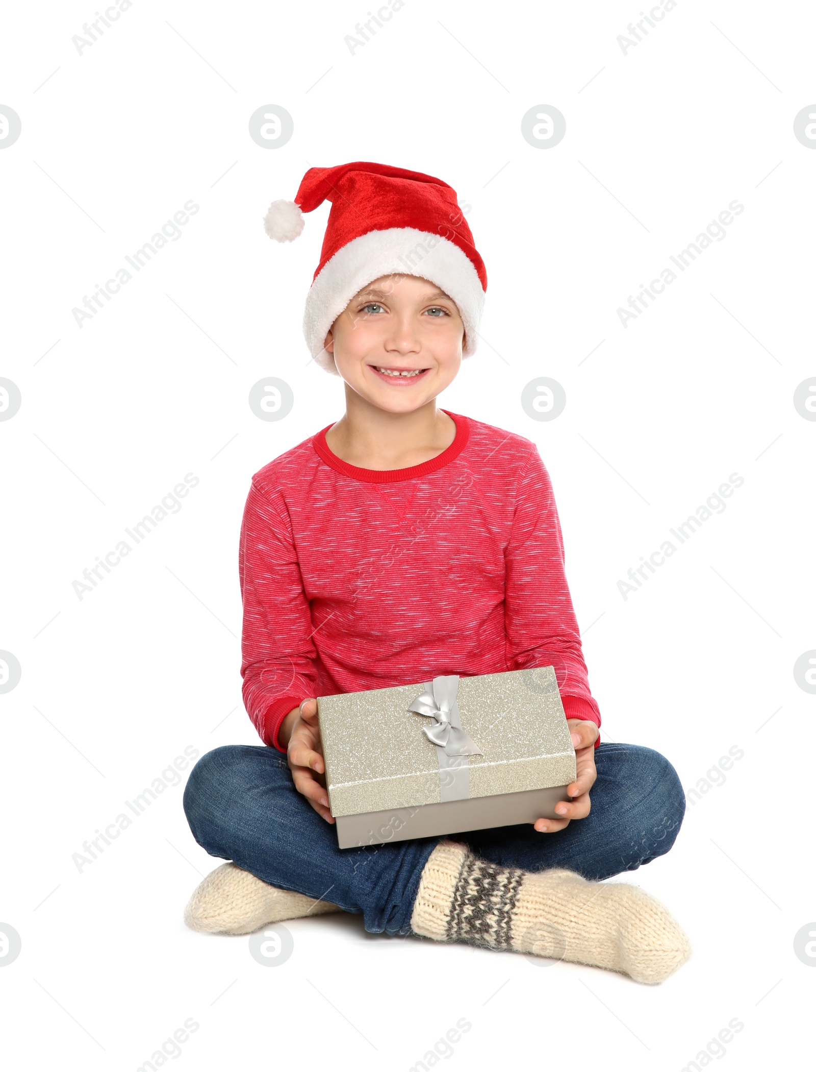 Photo of Cute little child in Santa hat with Christmas gift box on white background