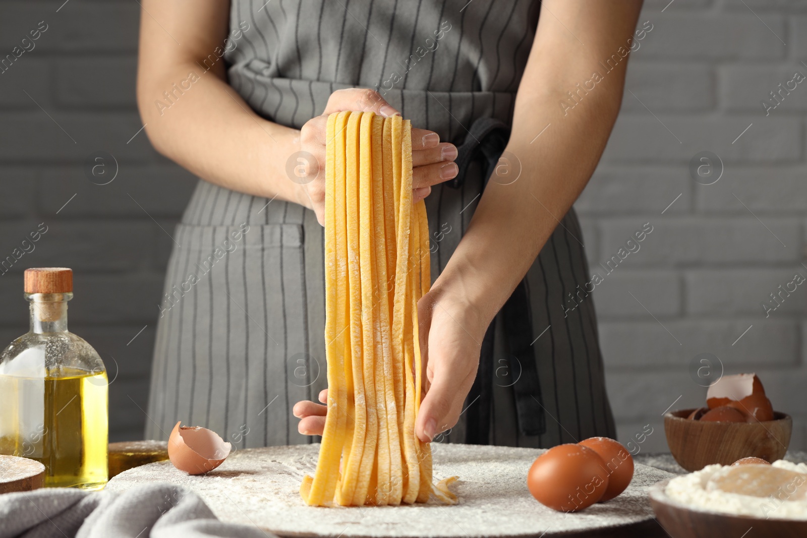 Photo of Woman making homemade pasta at table, closeup