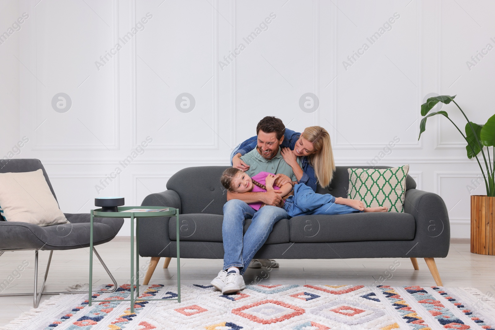 Photo of Happy family having fun together on sofa at home