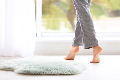 Photo of Woman walking barefoot in apartment, closeup. Floor heating