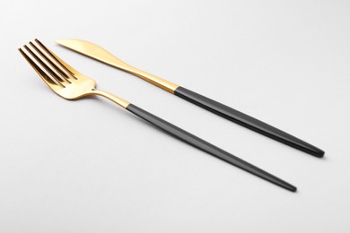 Stylish cutlery. Golden knife and fork on gray background
