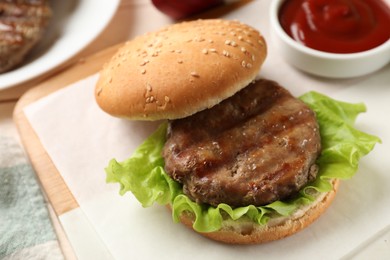 Photo of Delicious fried patty, lettuce, buns and sauce on table, closeup. Making hamburger