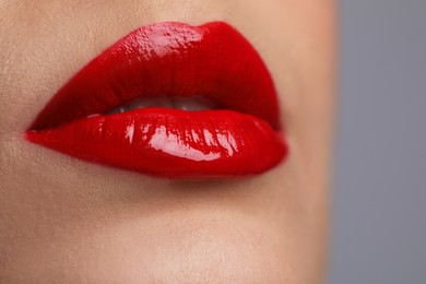 Photo of Closeup view of woman with beautiful full lips on grey background