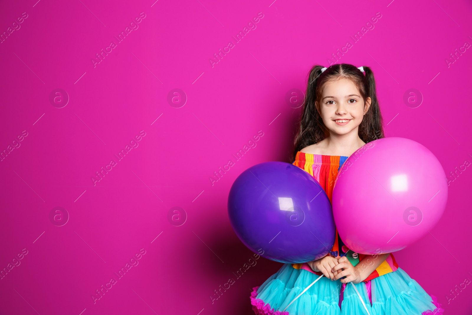 Photo of Cute girl with balloons on color background. Birthday celebration