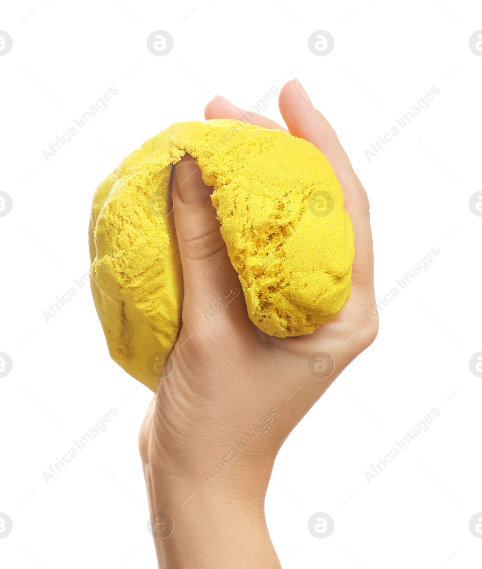 Photo of Woman playing with yellow kinetic sand on white background, closeup