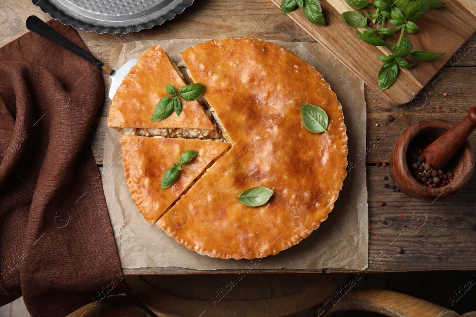 Photo of Delicious pie with meat and basil on wooden table, flat lay