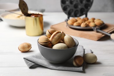 Delicious walnut shaped cookies with condensed milk on white wooden table