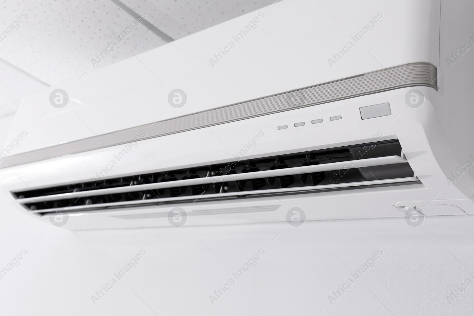 Photo of Modern air conditioner on white wall indoors, closeup view