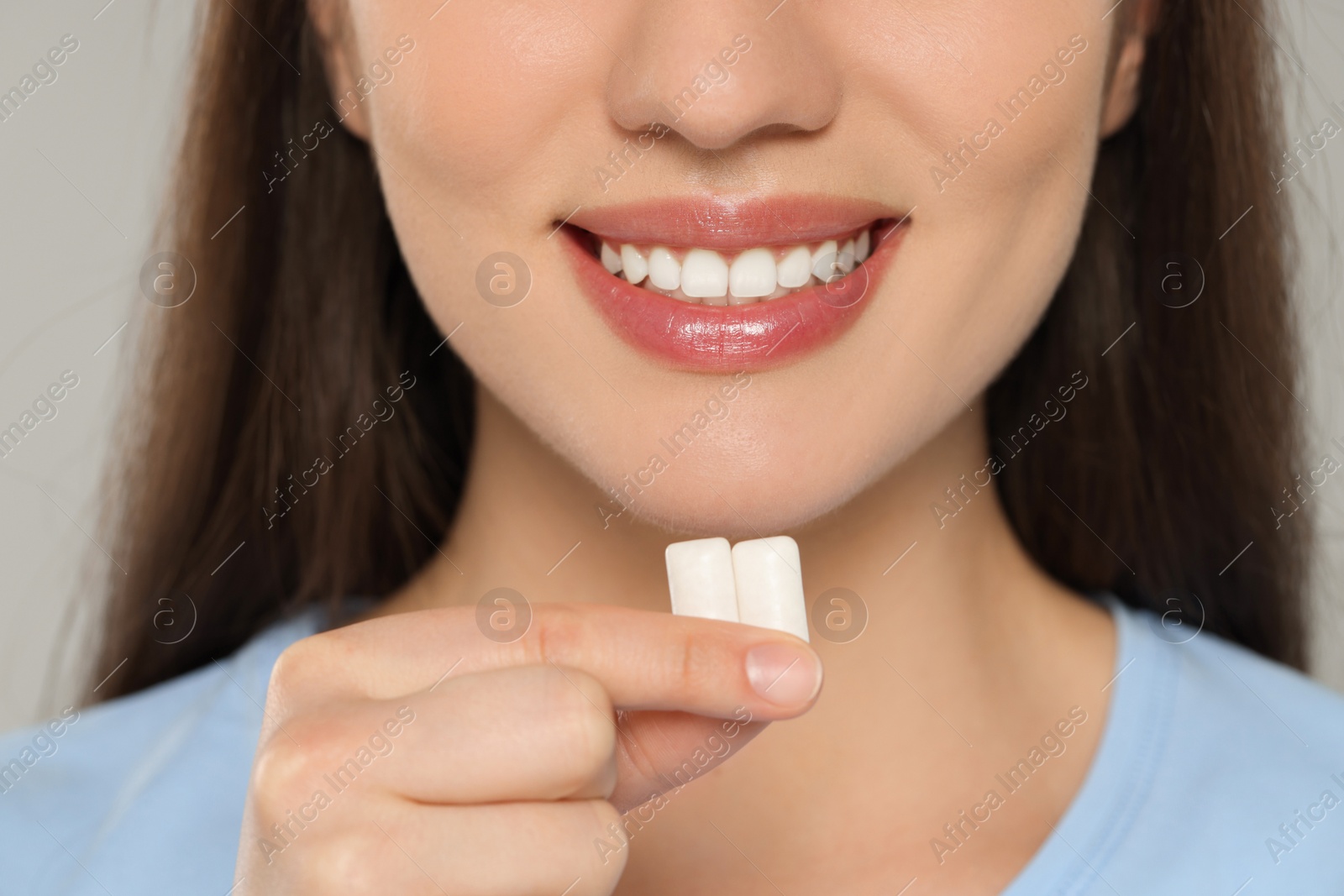 Photo of Woman with bubble gums on grey background, closeup