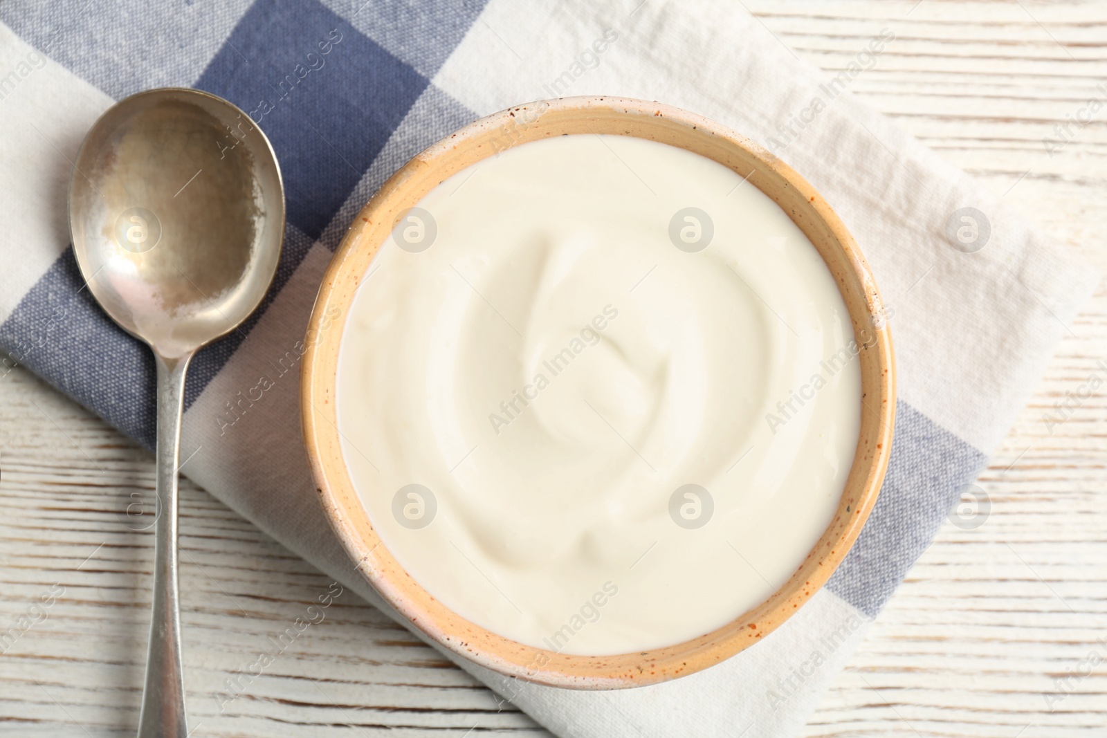 Photo of Bowl with yummy yogurt on wooden table