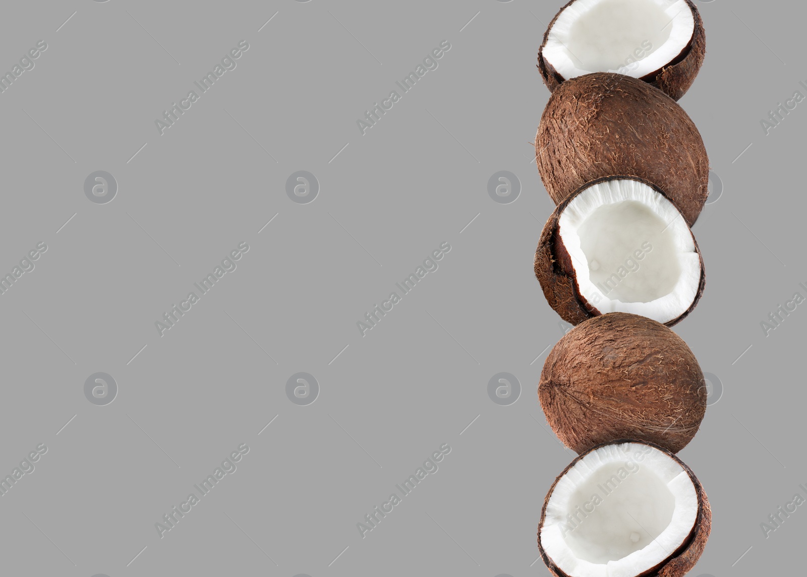 Image of Stack of fresh coconuts on light grey background. Space for text