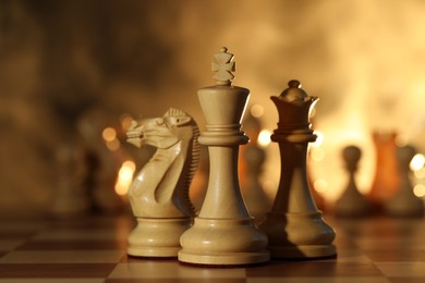Photo of Wooden king, queen and knight on chessboard, closeup