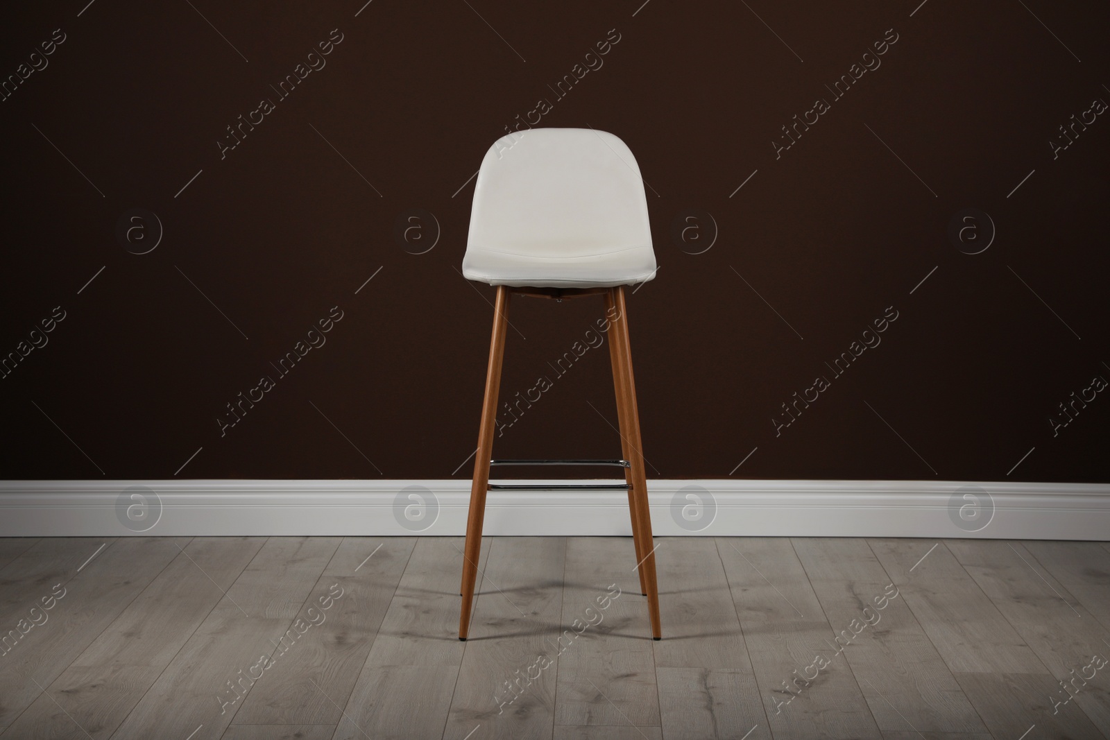 Photo of Stylish bar stool near brown wall indoors