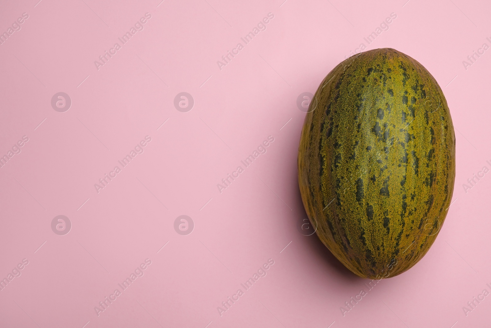 Photo of Whole ripe tasty melon on pink background, top view. Space for text