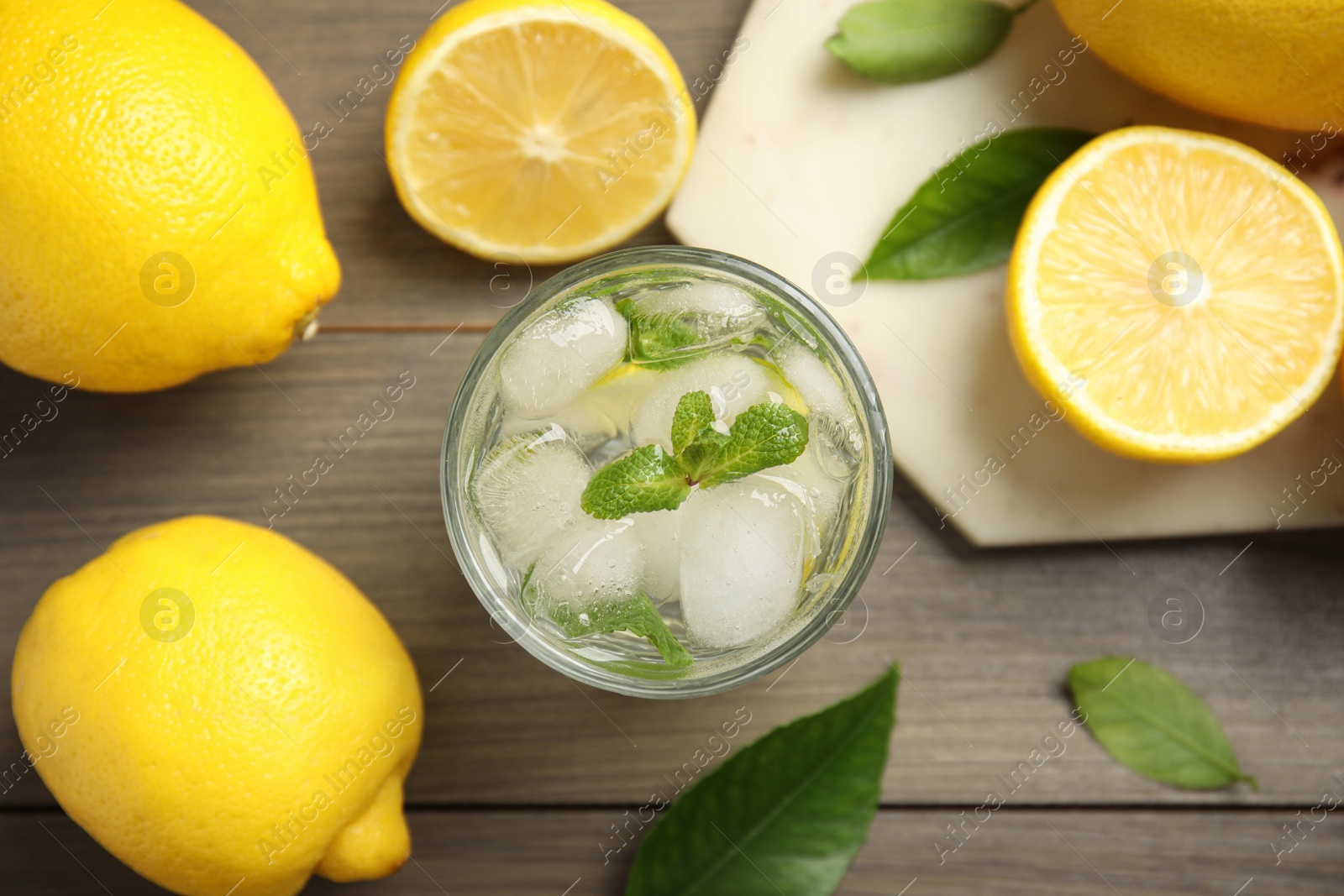 Photo of Cool freshly made lemonade and fruits on wooden table, flat lay