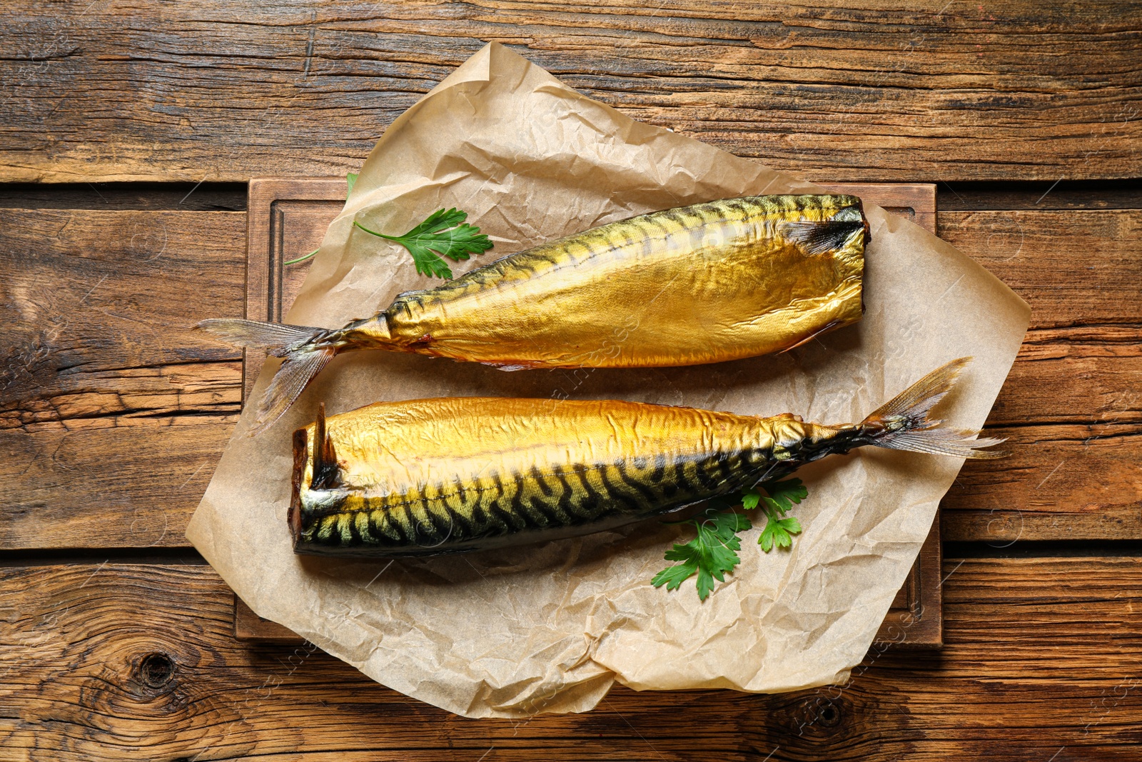 Photo of Tasty smoked fish on wooden table, top view