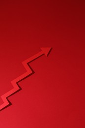Photo of One zigzag paper arrow on red background, above view. Space for text