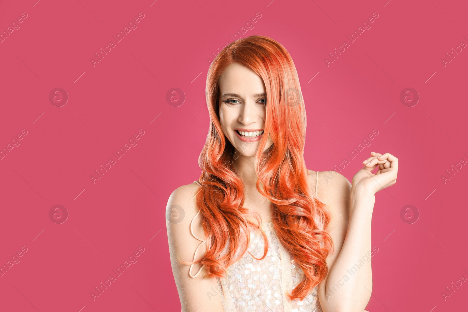 Image of Beautiful woman with long orange hair on pink background