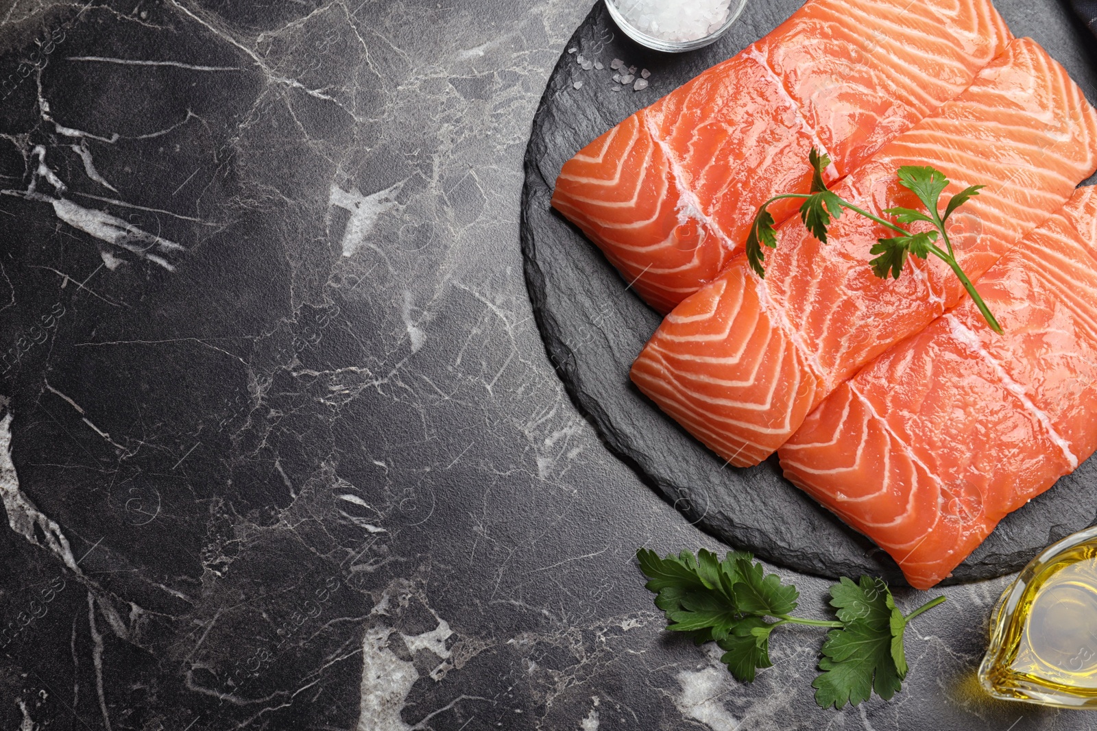 Photo of Flat lay composition with fresh raw salmon on black marble table, space for text. Fish delicacy