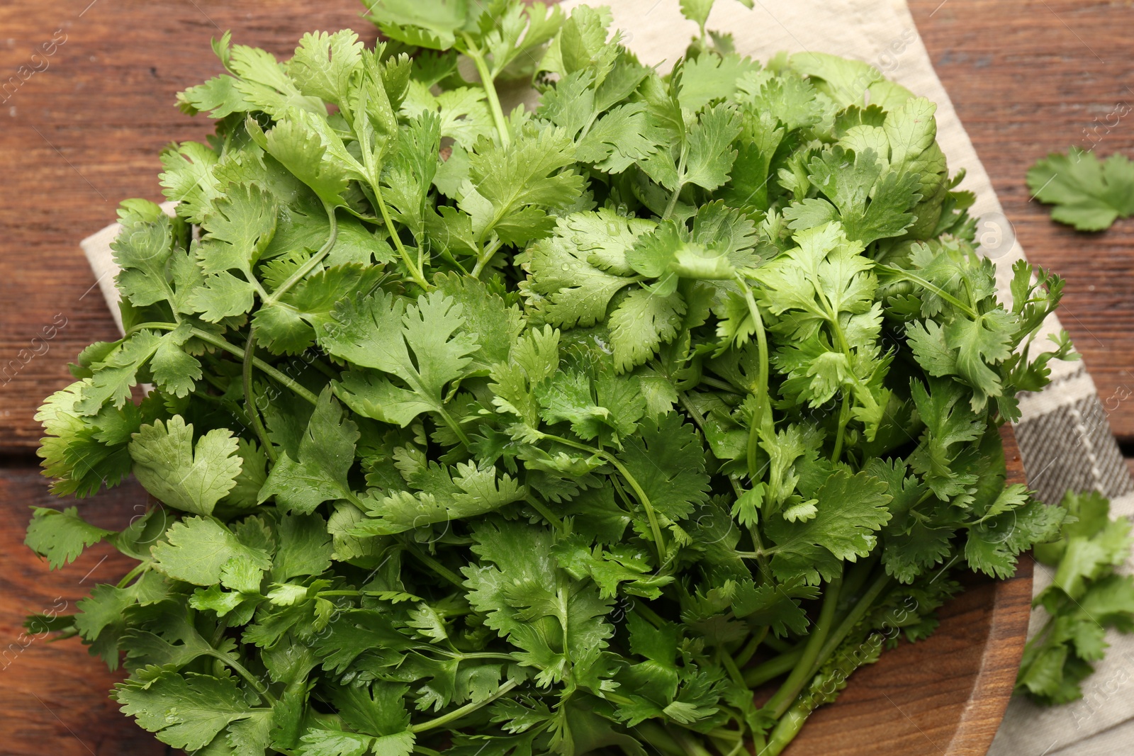 Photo of Fresh coriander on wooden table, top view