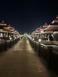 Paved pathway and buildings in city at night