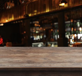 Image of Empty wooden surface and blurred view of bar interior. Space for design