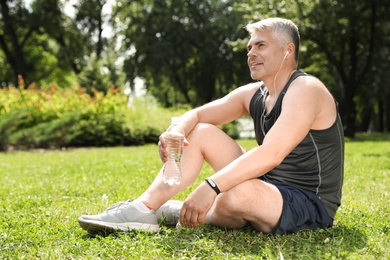Handsome mature man having rest after exercise in park. Healthy lifestyle