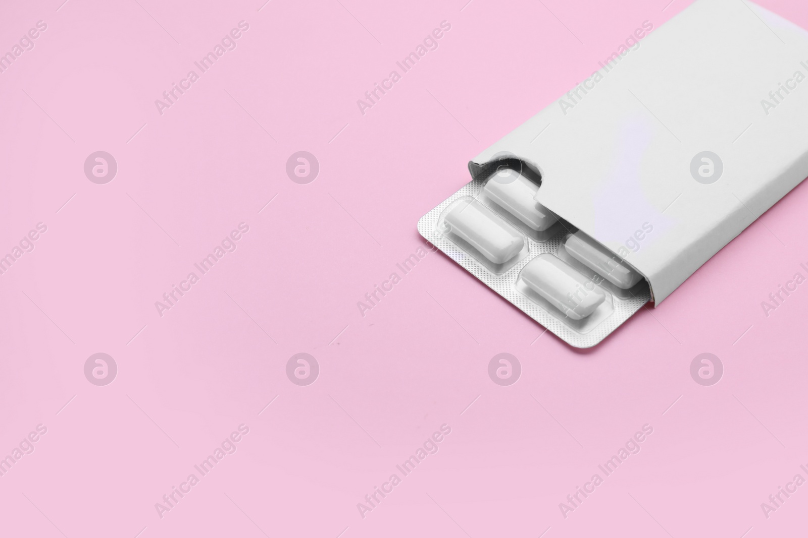 Photo of Blister with chewing gums on pink background. Space for text