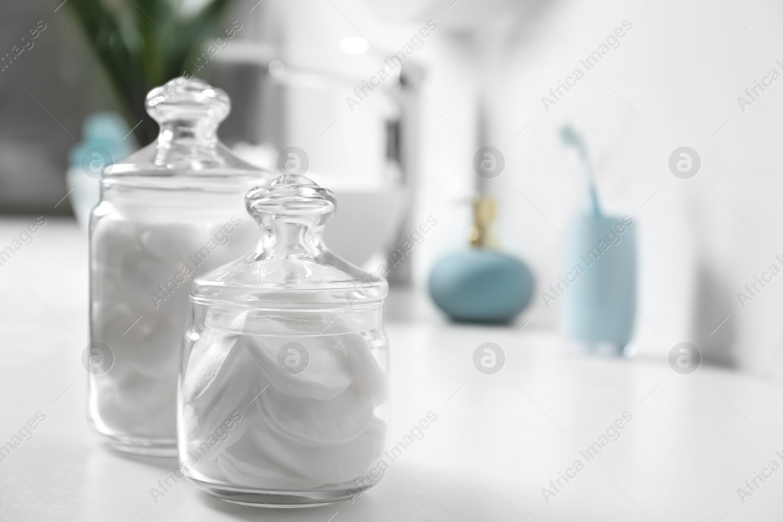 Photo of Cotton balls and pads on white table in bathroom