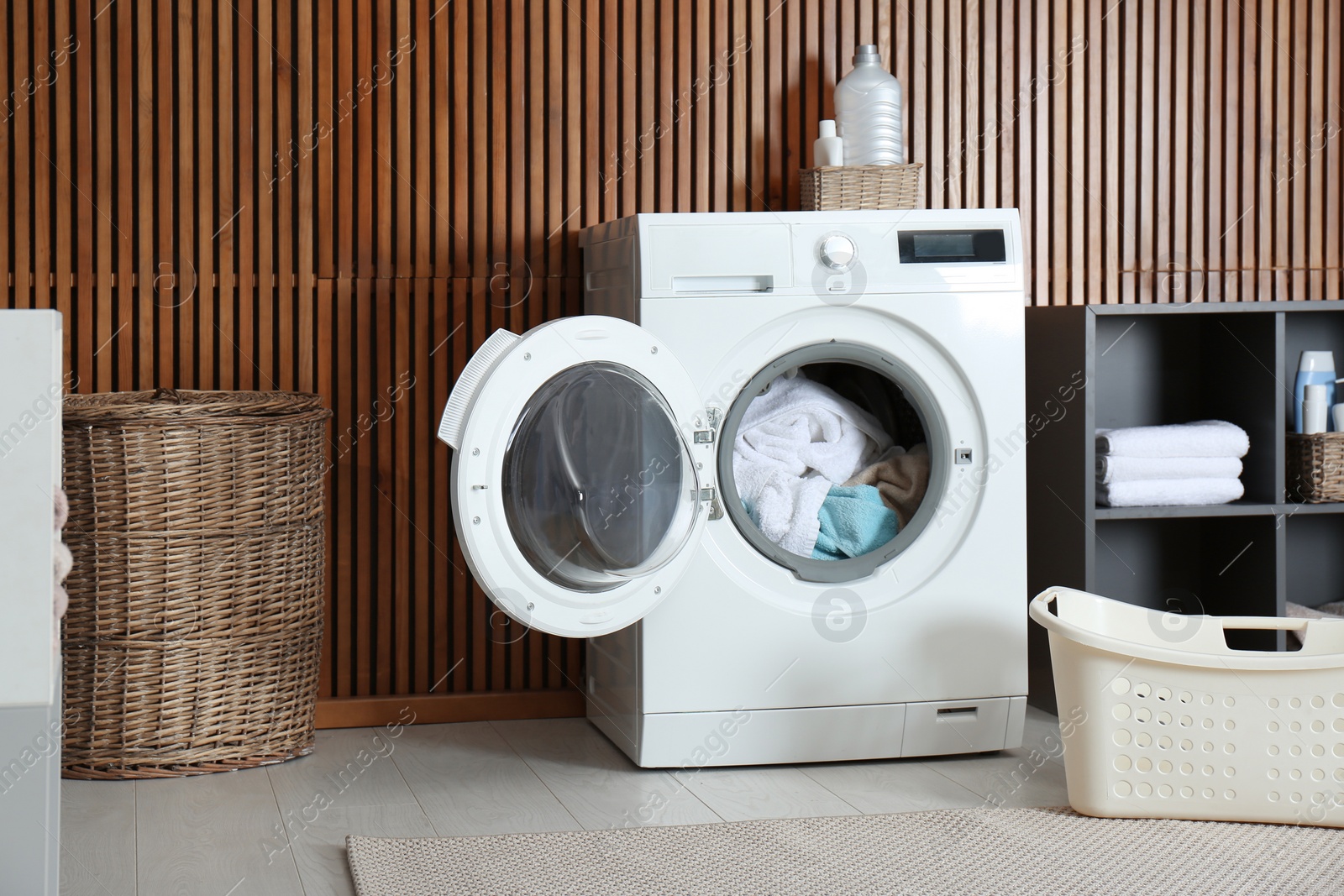 Photo of Crumpled towels in washing machine at home. Laundry room interior