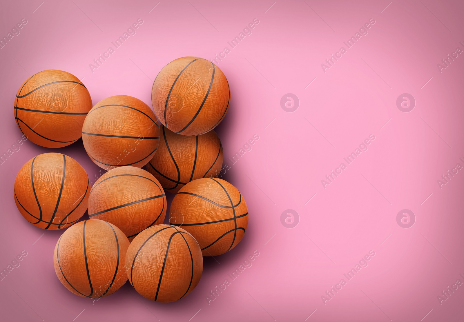 Image of Many orange basketball balls on pink background. Space for text