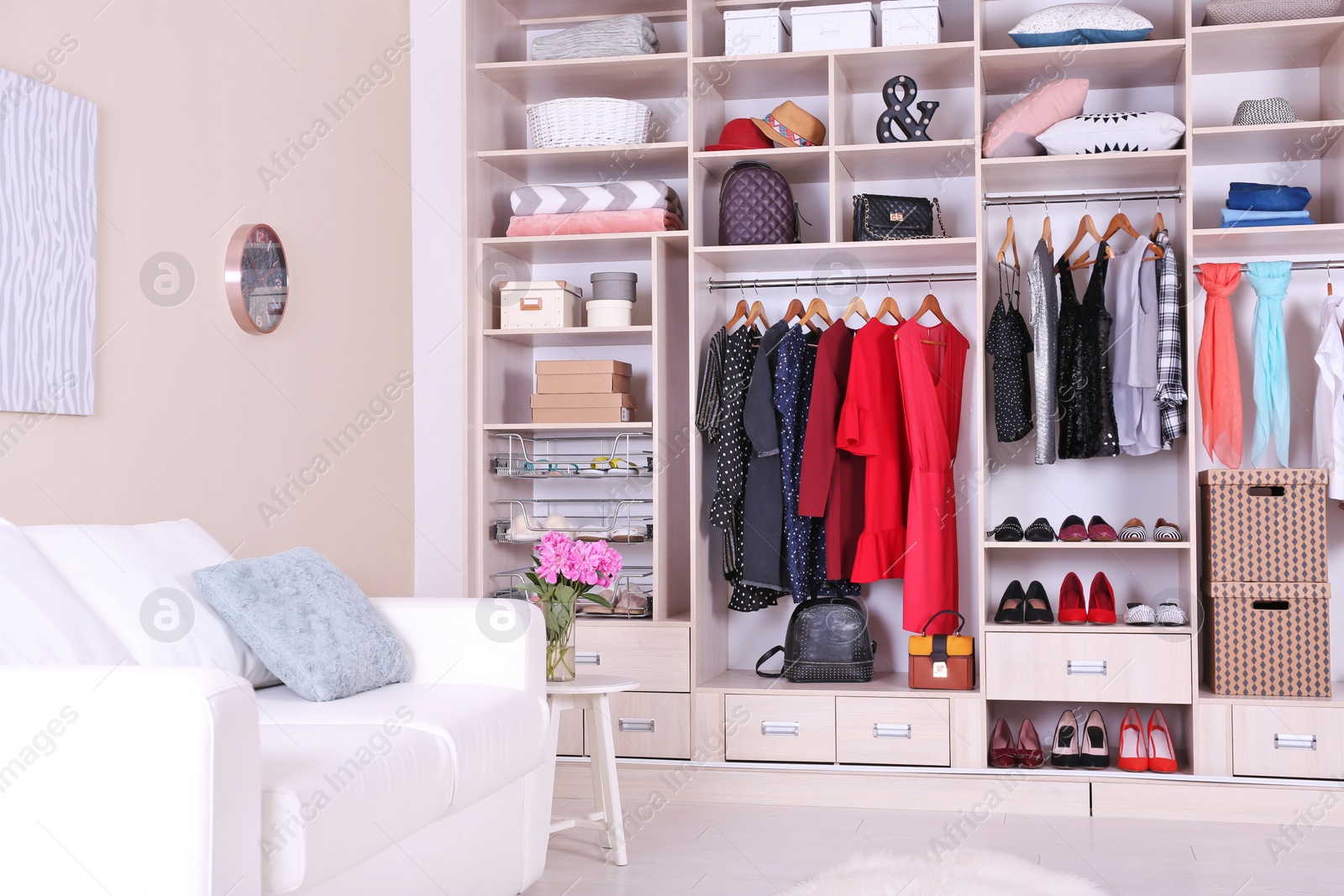 Photo of Modern wardrobe with stylish clothes in room interior