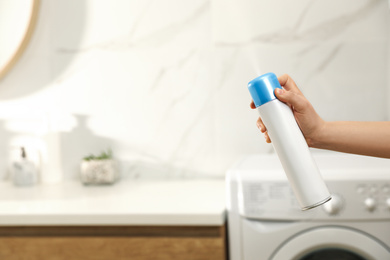 Woman spraying air freshener in bathroom, closeup