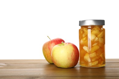 Photo of Tasty apple jam in glass jar and fresh fruits on wooden table against white background, space for text